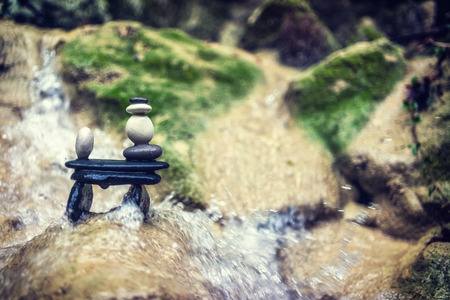Balanced Rock Zen Stack in front of waterfall.の写真素材