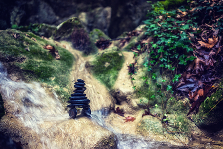 Balanced Rock Zen Stack in front of waterfall.の写真素材