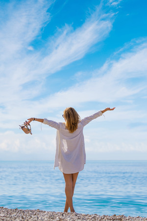 Outdoor summer portrait of young pretty woman looking to the ocean at tropical beach,の写真素材