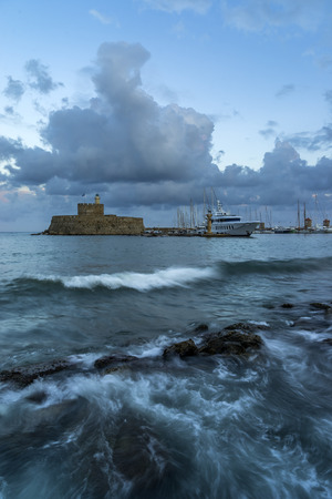 Agios Nikolaos fortress on the Mandraki harbour of Rhodes Greece at dusk