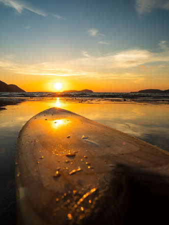 Surfboard on the beach at sunsetの写真素材