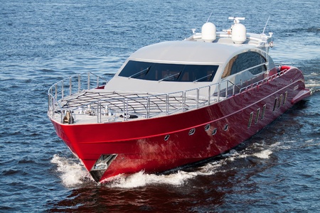 Luxury red speed boat with water splashesの写真素材