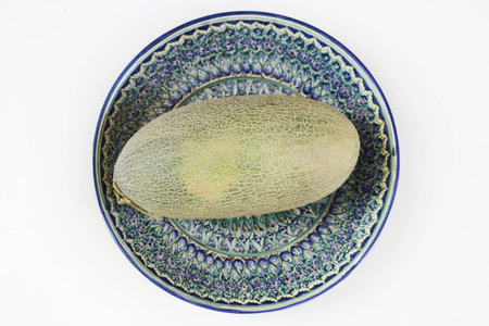 Melon from Uzbekistan is on a plate with Uzbek ornament.の写真素材