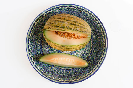 Melon from Uzbekistan is on a plate with Uzbek ornament.の写真素材