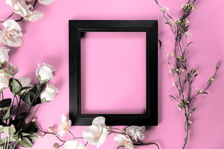 black frame on pink table with white flowers