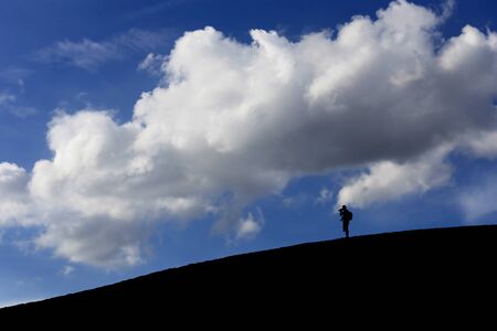 One man at white sand dune in early morning on blue sky, Muine, Vietnamの写真素材