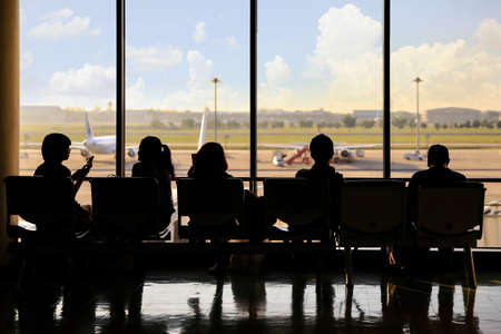 Man and woman wait airplane at airportの写真素材