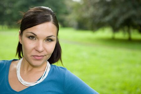 attractive brunette woman in parkの写真素材
