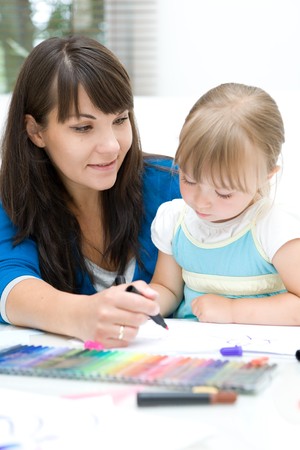 mother and daughter having fun in kindergartenの写真素材