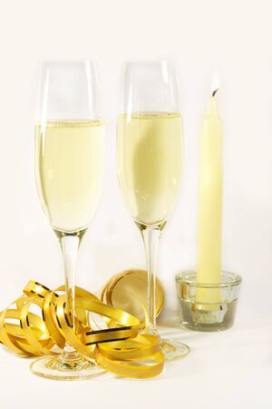 two flutes of champagne with canddle and golden ribbonの写真素材