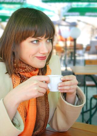 Young lady with a cup of espresso in the outdoor cafeの写真素材