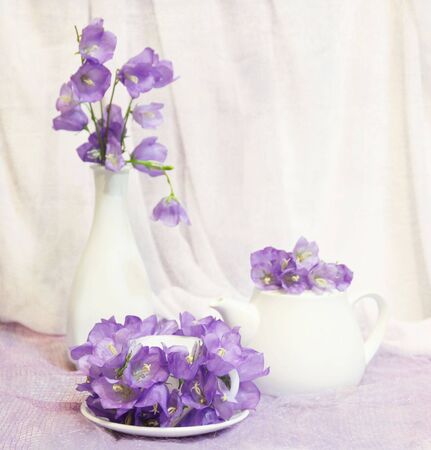 Beautiful still life with tea cup, teapot and violet bell flowersの写真素材
