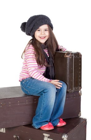 Funny little girl with the old suitcases over the white backgroundの写真素材