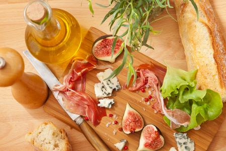 Ham, cheese and figs on the wooden boardの写真素材
