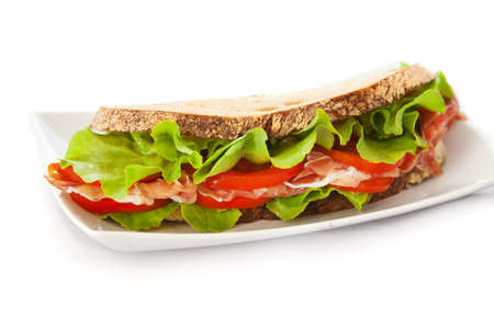 Sandwich with ham, tomatoes and salad over the white backgroundの写真素材