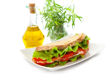 Sandwich with ham, tomatoes and salad over the white backgroundの写真素材