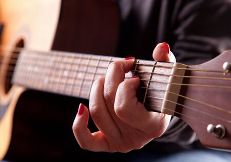 Close-up of woman playing acoustic guitar