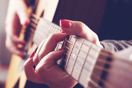 Close-up of woman playing acoustic guitar