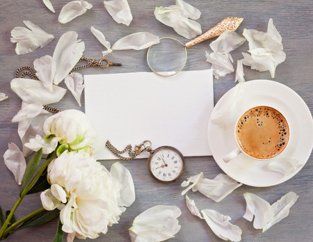 Flat lay of empty card, coffee cup,  old pocket watch and flowers with copy space. Top veiwの写真素材