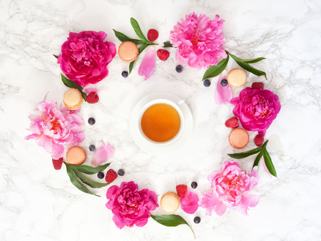 Tea time. Flat lay over light background with peonies  and cup of teaの写真素材