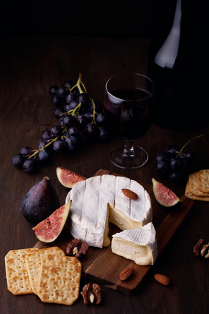 French cheese camembert with glass of red wine, grapes and figsの写真素材
