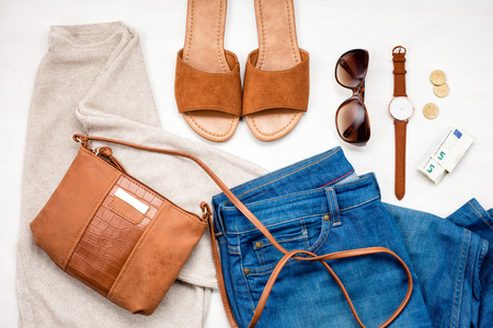 Summer street style. Fashion summer girl clothes set, accessories. Trendy sunglasses, slippers, handbag clutch,  watch, jeans. Summer lady. Creative urban overhead summer top viewの写真素材