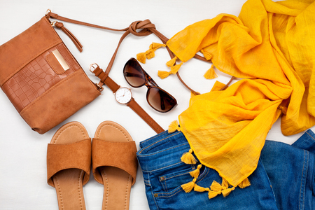 Summer style. Fashion summer girl clothes set, accessories. Trendy sunglasses, slippers, handbag clutch,  watch, jeans, scarf. Summer lady. Creative urban overhead summer top viewの写真素材