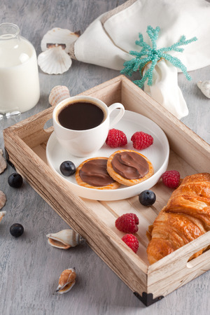 Romantic breakfast with coffee, croissant, chocolate cookies and berriesの写真素材