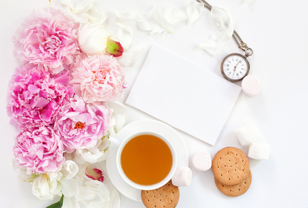 Flat lay over light background with peonies and cup of tea.の写真素材
