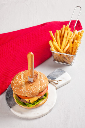 Fresh tasty burger with cheese, tomato and salad with french friesの写真素材