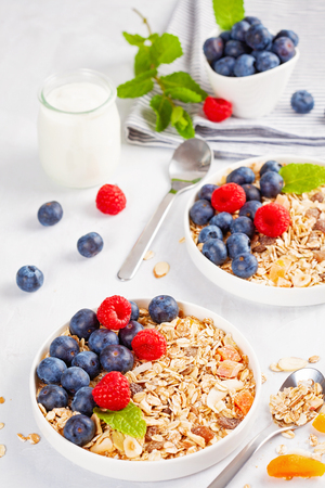 Homemade granola or oatmeal muesli with nuts, dried fruits and fresh berries. Healty diet breakfast, vegeterian food conceptの写真素材