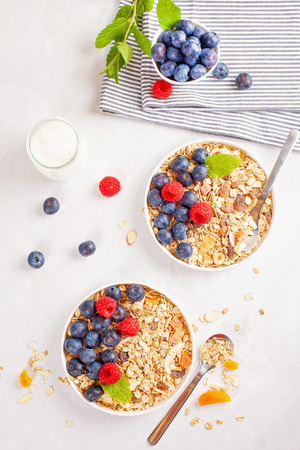 Homemade granola or oatmeal muesli with nuts, dried fruits and fresh berries. Healty diet breakfast, vegeterian food conceptの写真素材