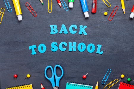 Back to school text with colorful stationary over the blackboard backgroundの写真素材