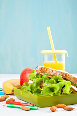 Fresh sandwich, apple and orange juice for healthy lunch of a kid or a student in the plastic lunch boxの写真素材