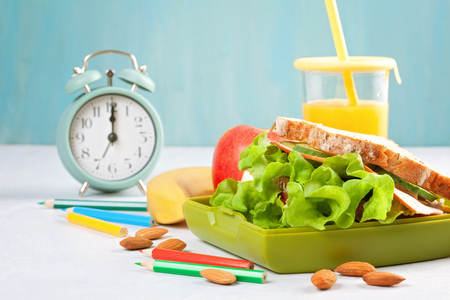 Fresh sandwich, apple and orange juice for healthy lunch of a kid or a student in the plastic lunch boxの写真素材