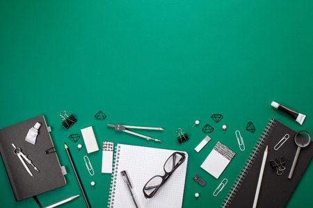 Black and white stationary and office supplies over the green board background with copy space for textの写真素材