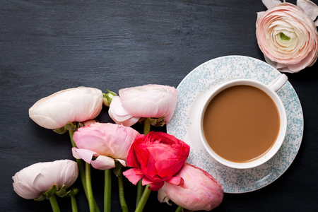 Top view to pink flowers and cup of coffee with milkの写真素材