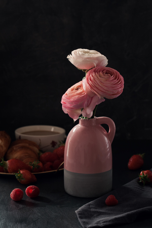 Romantic breakfast ith coffee, croissants and beautiful bouquet of flowers. Dark photoの写真素材