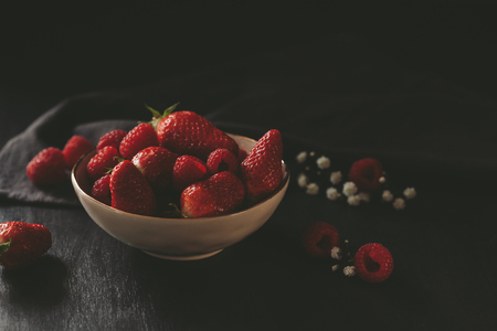 Dark moody food photography with fresh strawberries and raspberriesの写真素材