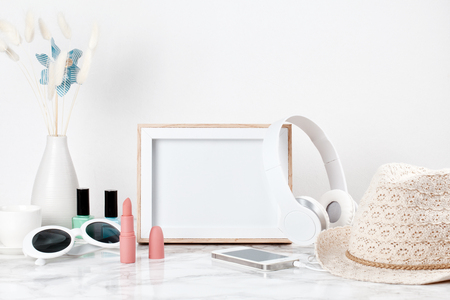 Poster frame mockup, front view, with decor elements and female accessories, flowers and blank copy space over the white wall.の写真素材