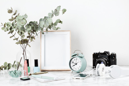 Poster frame mockup, front view, with decor elements and female accessories, flowers and blank copy space over the white wall.の写真素材
