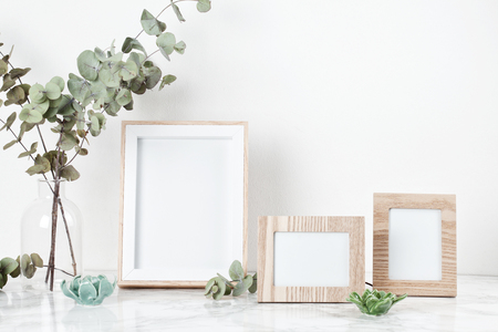 Three frames mockup, front view, with decor elements, flowers and blank copy space over the white wall.の写真素材
