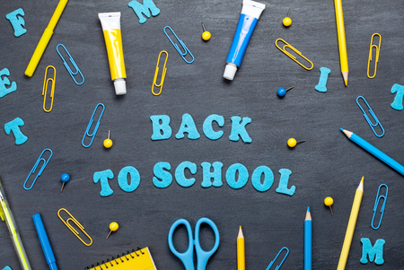 Back to school text with colorful stationary over the blackboard backgroundの写真素材