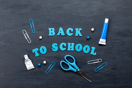 Back to school text with colorful stationary over the blackboard backgroundの写真素材