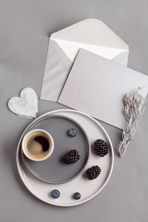 Top view over coffee cup, and gray postcard with envelopeの写真素材