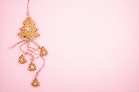 Traditional wooden Christmas decoration over pastel pink backgroundの写真素材