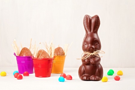 Easter composition with chocolate eggs and bunny on  wooden background, space for textの写真素材