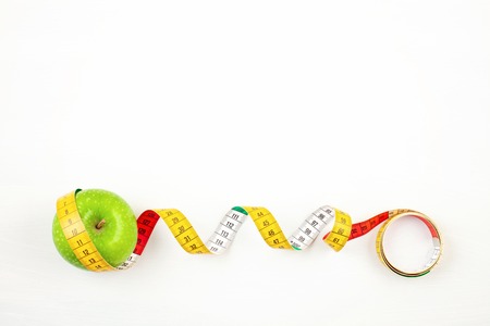 Apple and measuring tape with copy space for diet, weight loss and fitness planning. Healthy...