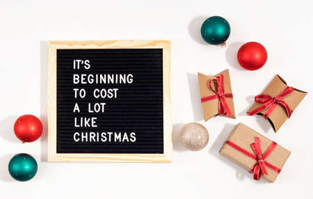 Felt letter board with funny quote text It is beginning to cost a lot like Christmas. Spemding money on expensive xmas gifts conceptの写真素材
