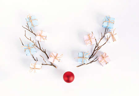 Christmas reindeer concept made of branches and xmas bauble on white background. Minimalist winter seasonal idea. Flat lay, top view compositionの写真素材